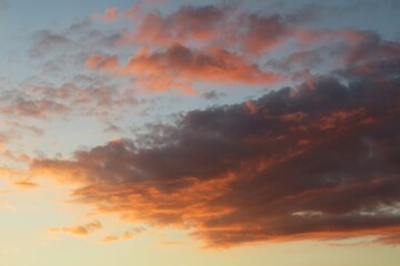 Naklejka na ściany i meble Dramatic orange black clouds in the sky at sunset, natural background