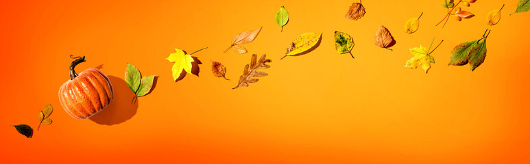 Naklejka premium Autumn pumpkin with colorful leaves overhead view - flat lay