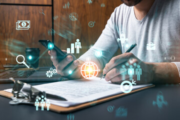 Double exposure of man signing contract with phone and business theme icon hologram. Concept of investment.