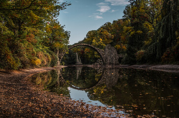 Ancient stone bridge in water reflection