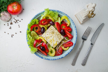 Greek salad with feta on white concrete table