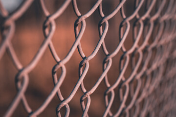 A close up of the links of a chain link fence using selective focus