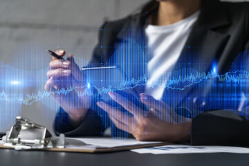 Businesswoman taking notes using smart-phone. Financial forex graph and chart hologram double exposure.