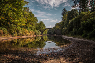 Ancient stone bridge in water reflection