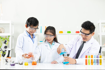 science teacher doing or testing a chemical experiment with child students in laboratory classroom