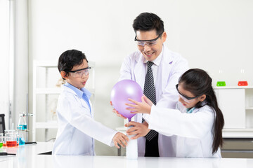 science teacher doing or testing balloon blow up experiment from bottle with child students