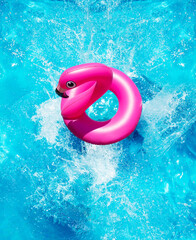 Inflatable flamingo buoy splash into the swimming pool view from above