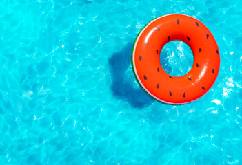 Inflatable red watermelon with seeds buoy swim in the swimming pool view from above
