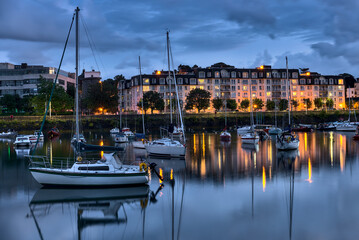 Fototapeta na wymiar Boats in Dun Laoghaire harbor. The West Pier during the blue hour. Evening shot of the harbor in Dublin, Ireland