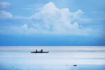 Fototapeta na wymiar Fisherboat in the blue white ocean and huge cloud at Siquijor with mountain, Philippines, Asia