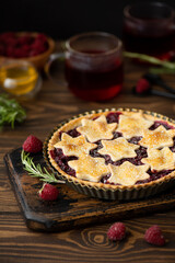 homemade raspberry pie made from crumbly dough and hibiscus tea on a wooden table