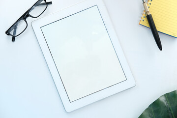 top view of digital tablet with office suppliers on white background 