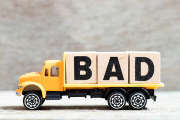 Truck hold letter block in word bad on wood background
