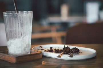 Dirty plate with cake crumbs leftovers and dirty a glass after enjoy eating