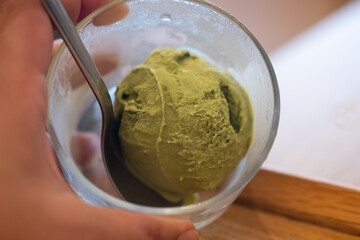 Green tea matcha ice cream scoop in glass bowl