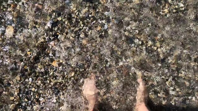 Feet on a rocky beach by the sea