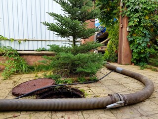 The open hatch of the septic tank. The cast-iron lid is next to it. Sewage treatment