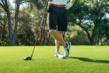 Male golf player with golf club on professional golf course
