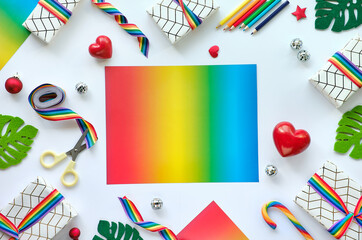 Frame made of Christmas gifts with rainbow ribbon in LGBTQ community flag colors. Flat lay, Xmas decor, copy-space.