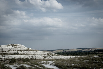 Lake with blue transparent water in the white mountains. Deserted hills are formed from chemical wastes of phosphogypsum. Pollution of nature