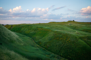 Beautiful field landscape. Countryside village rural natural background at sunny weather in  summer. Green grass and blue sky with clouds. Nature protection concept.