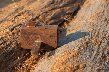 A small vintage planer rests on a stick and the sunlight blurs.
