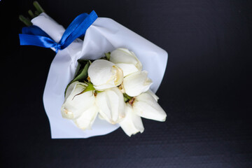 bouquet of white roses on black background and space for text
