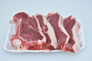 fresh chopped slices of lamb meat decorated in plate on white background,