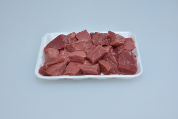 fresh boneless lamb meat chopped cubes isolated in plate,uncooked raw mutton pieces closeup