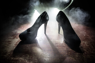 Silhouette of a high heel women shoes at dark. Women power or women domination concept.
