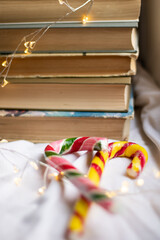 Colored caramel staves and books lie on a white background	
