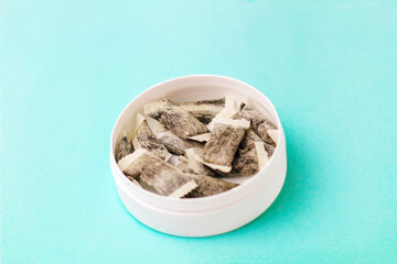 Round box with snus. Cigarette substitute, nicotine pouches.