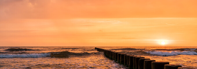 Sun rising behind the horizon at the Baltic Sea - obrazy, fototapety, plakaty