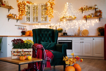 Autumn kitchen studio interior. Red and yellow leaves and flowers in the vase and pumpkin on light background