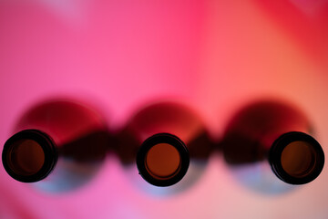 Three wine bottles viewed from top in a red background