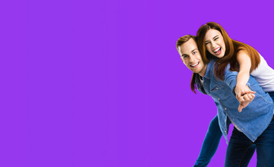 Smiling amorous funny couple. Portrait image of standing piggy back ride models in love studio...