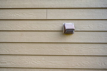 Residential vent pest screen on the side of a house