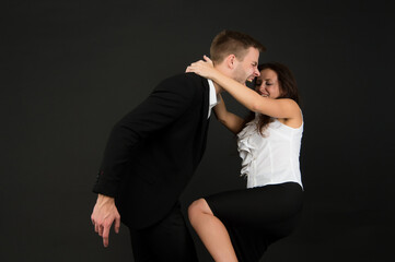 Violent woman in formal wear kneed businessman in groin dark background, violence