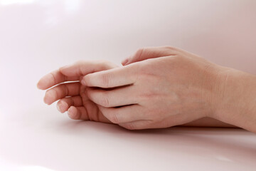 Woman hands lie on a white background.
