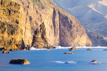 Rocky coast with cliff above the sea. Rock formations of the Canary Islands on the Atlantic ocean.