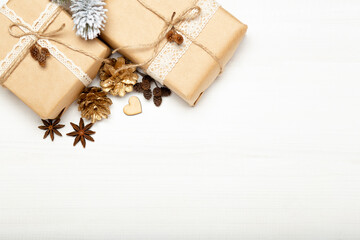 Christmas composition, Christmas gifts, golden pine cones on white wooden background copy space