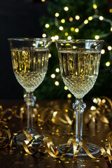 Close-up of two glasses with bubbly champagne on  background of  sparkles