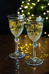 Pair glass of champagne on wooden table, on  background of  sparkles and fir tree