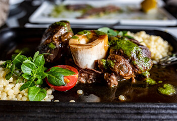 still life with a piece of meat on the bone with a side dish