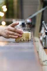Person holding a glass alcoholic summer cocktail