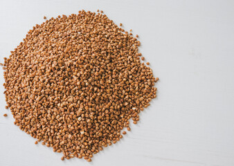 Closeup of the buckwheat on white wooden background.