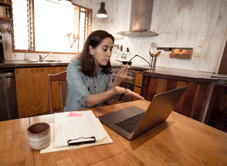 Attractive young business woman working from home on her computer stressed, tired and overwhelmed