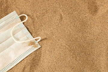 Waste during COVID-19. Scrapped to ocean coronavirus single-use face masks. Environmental and coastal plastic pollution. Trash on the beach that threatens the health of the oceans.