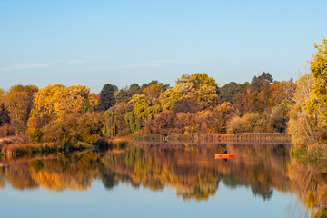 Beautiful autumn landscape with reflection of trees in a forest lake