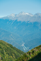 natural wallpaper with high mountains in fog and green hill